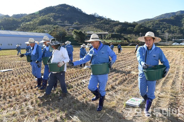 최정우 회장이 직원들과 함께 진월면에서 ‘규산질 슬래그 비료 뿌리기 봉사활동’을 하고 있다.